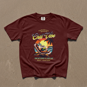 Model wearing a maroon premium cotton t-shirt with a bold retro Chill Vibe slogan and a funny lounging beach cat illustration