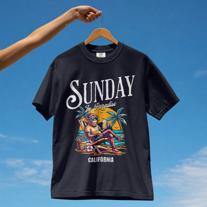 Model wearing a navy premium cotton t-shirt with a vintage white Sunday in Paradise slogan and a colorful chilling beach monkey illustration