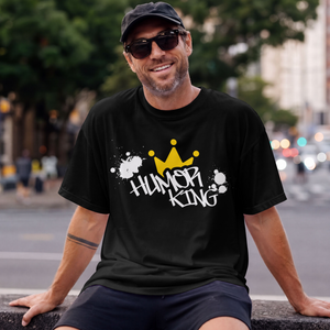 showing a black streetwear t-shirt featuring a handwritten style Humor King slogan and a clean yellow crown logo